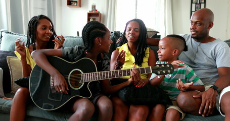 Family enjoying music together, joyful African black parents and children bonding together
