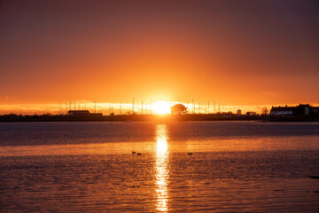 Fototapeta na wymiar sun setting over the sea with Langstone bridge in the background 
