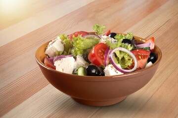 Healthy salad bowl with different lettuce, chicken, cheese on the table in restaurant.