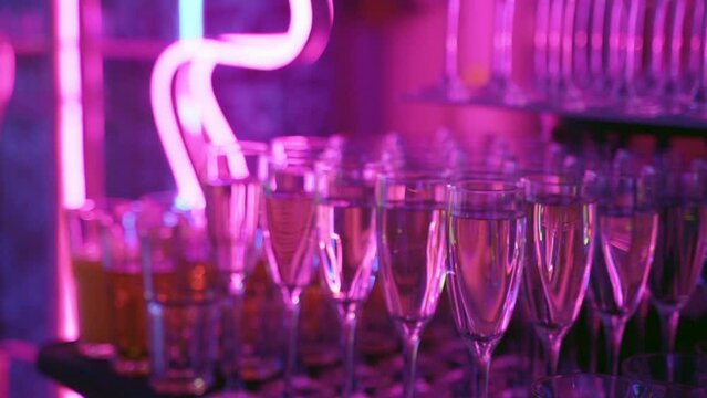 Glasses of champagne in purple light