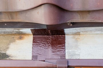 Repair of metal gutters on metal roof with self-adhesive waterproofing bituminous tape TechnoNIKOL....