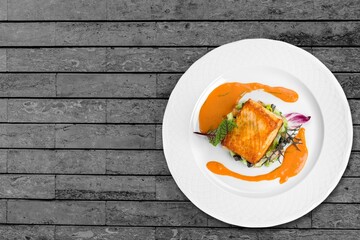baked fish steak with mustard, lemon, rosemary on a plate