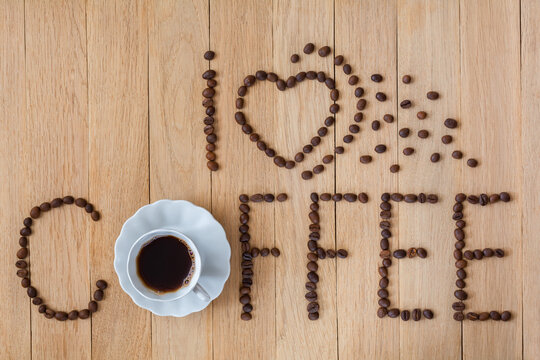 The inscription "I love coffee". Romantic composition with coffee beans on a wooden background
