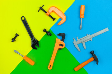 Set of toy working tools on colorful paper background. industrial background concept