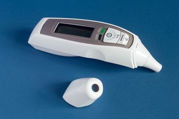 Infrared Forehead and Ear Thermometer with LCD display and fever alarm with the cap removed on a...