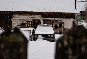 Abandoned oldtimer and lost farmhouse covered in snow in a small village in slovakia