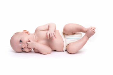 cute baby in a diaper lies on its side on a white isolated background