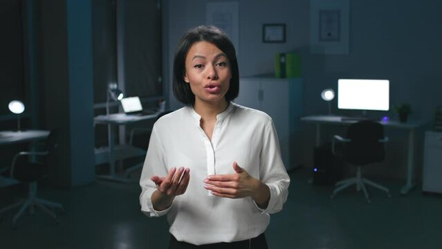Portrait of African-American businesswoman look at camera and speak standing in dark office