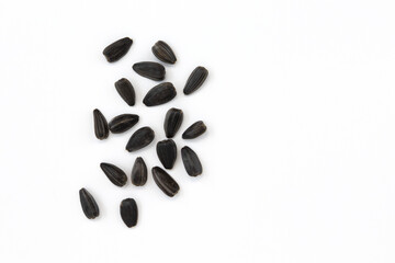 black sunflower seeds isolated on white background with copy space for text, top view of pile of roasted unpeeled seeds
