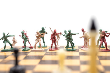 Photo plastic toy soldiers on a chessboard