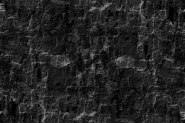 Naklejka premium Abandoned old rugged surface of a dark stone wall for texture background