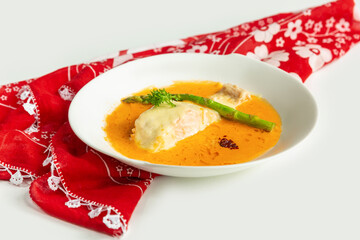 Pan-fried Salmon fish with gravy in a dish isolated on colorful table cloth top view on grey background