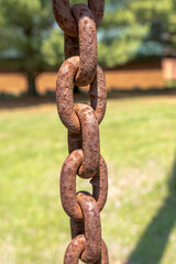 A thick heavy rusty chain hanging vertically