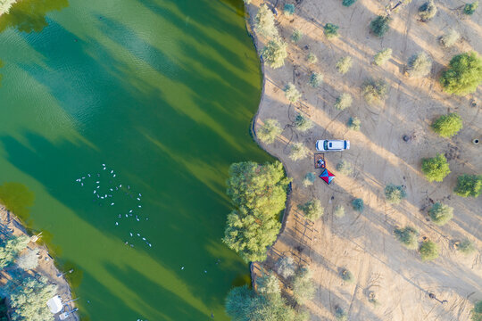 Aerial view of a vehicle stopping along Al Quadra lakes in Dubai, United Arab Emirates.