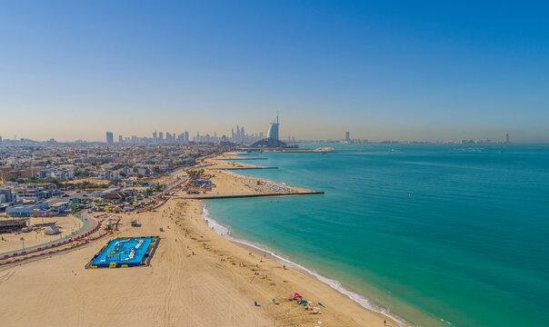 Aerial view of people relaxing on the beach along the coast in summertime, Dubai, United Arab Emirates.