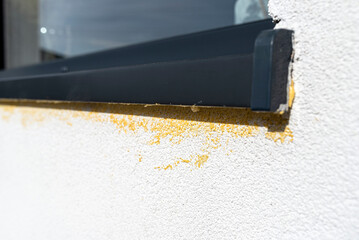 Yellow mounting foam filled under the window sill, white plaster is stained by sloppy work.