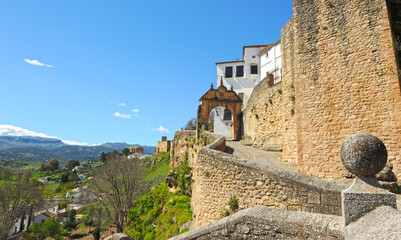 Fototapeta na wymiar Walls and Gate of Felipe V in Ronda, Malaga province, Andalusia, Spain. Ronda is one of the most interesting monumental cities in Andalusia