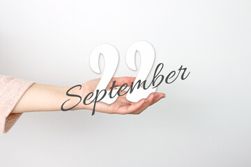 September 22nd. Day 22 of month, Calendar date. Calendar Date floating over female hand on grey background. Autumn month, day of the year concept.