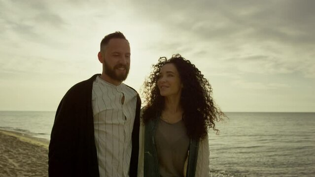 Happy lovers walking sea sunset beach outdoors. Hispanic couple enjoy coast.