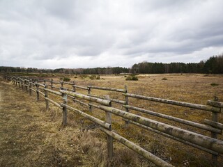 wooden fence in a meadow and landscape with trees