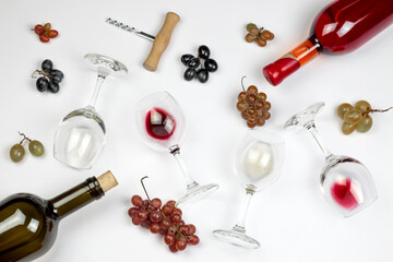 Wine bottles and glasses with different wine, corkscrews and grape bunches on grey background. Top view, flat lay, image. Wine degustation concept.