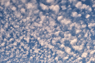 Bright landscape of white puffy clouds spread on blue clear sky