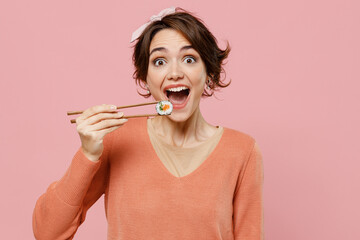 Young excited happy cool fun caucasian woman 20s wear casual clothes hold in hand with chopsticks...