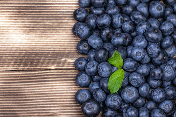Blueberry background. Ripe blueberry on wooden background.