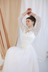 girl in a white wedding retro dress. wedding dress and hairstyle in the style of the 90's. Studio photo shoot in my mother's wedding dress. Bride photo shoot in the studio