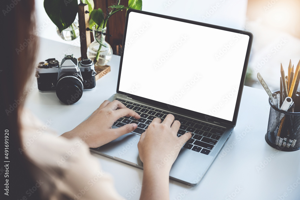 Fototapete Young woman using work from home computer to avoid the risk of contracting coronavirus in the company at work, the blank space on the computer screen can insert text.