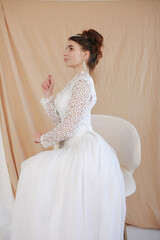 girl in a white wedding retro dress. wedding dress and hairstyle in the style of the 90's. Studio photo shoot in my mother's wedding dress. Bride photo shoot in the studio