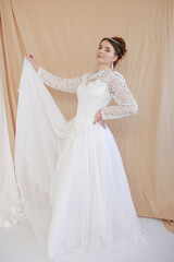 girl in a white wedding retro dress. wedding dress and hairstyle in the style of the 90's. Studio photo shoot in my mother's wedding dress. Bride photo shoot in the studio