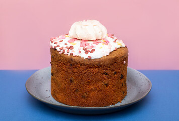 Easter cake with sweet fudge in a blue plate on a blue-pink background