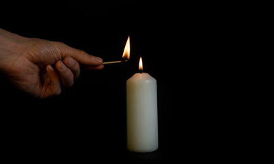 Ukraine, match lit a candle on a black background