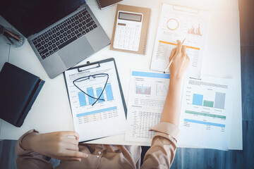 economists and accountants , data analysts are using calculators to calculate budgets and investments using statistical documents and computers to work at their desks.