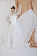 girl in a white wedding retro dress. wedding dress and hairstyle in the style of the 90's. Studio photo shoot in my mother's wedding dress. Bride photo shoot in the studio