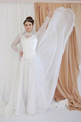 girl in a white wedding retro dress. wedding dress and hairstyle in the style of the 90's. Studio photo shoot in my mother's wedding dress. Bride photo shoot in the studio