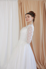 girl in a white wedding retro dress. wedding dress and hairstyle in the style of the 90's. Studio photo shoot in my mother's wedding dress. Bride photo shoot in the studio