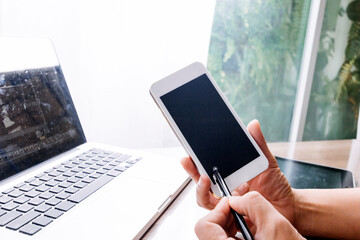 Business partnership coworkers using a tablet to chart company financial statements report and profits work progress and planning in office room.