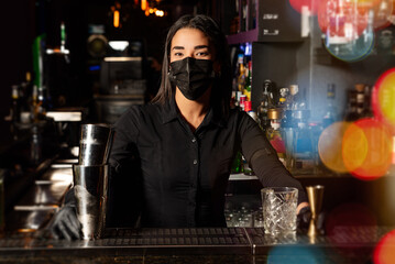 The young brunette Latina prepares a cocktail at the bar counter. job waitress profession