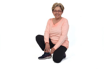 front view of a smiling  senior woman squatting on white backgrond