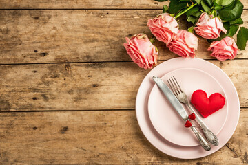 Romantic dinner table on rustic background. Love cutlery for Valentine's or Mother's day, Wedding