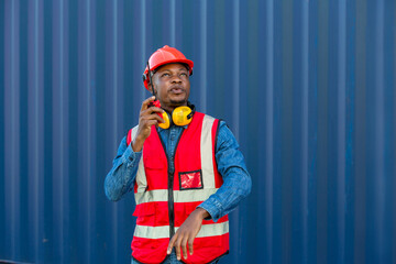 Foreman holding walkie- talkie for control working at Container cargo site. Handheld walkie talkie...
