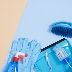 Creative copy space background scene with cleaning tools on pastel bright blue background. Flat lay minimal