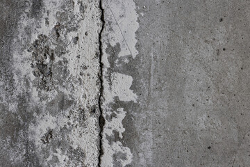 Texture of an old cracked concrete wall. Rough gray concrete surface. The gap between the reinforced concrete slabs. Perfect for background and design. Close-up. High resolution.