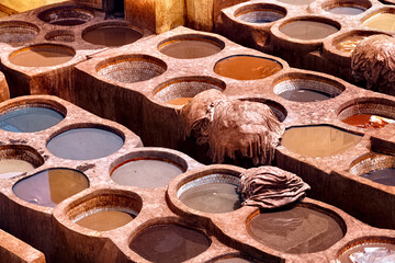 Old tannery in Fez, Morocco. The tanning industry in the city is considered one of the main tourist attractions. The tanneries are packed with the round stone wells filled with dye.