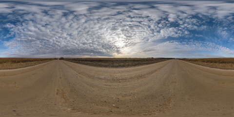Fototapeta na wymiar full seamless spherical hdri panorama 360 degrees angle view on no traffic gravel road among fields in summer evening sunset with awesome clouds in equirectangular projection, ready for VR AR