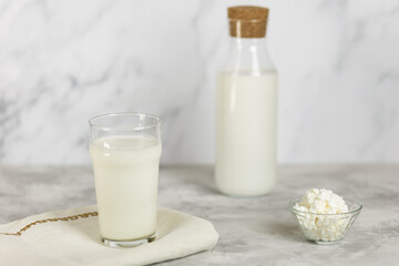 A glass and a bottle of kefir and natural granules on a concrete table. Healthy eating. Selective focus.