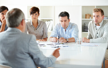Around the meeting table. Cropped shot of a business meeting in progress.