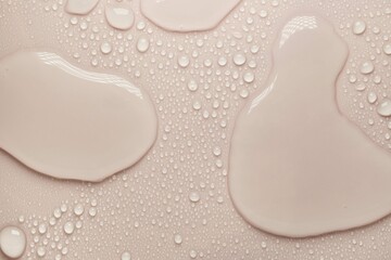 Cosmetic moisturizing liquid drops on beige pastel background. Toner or lotion. Hyaluronic serum
